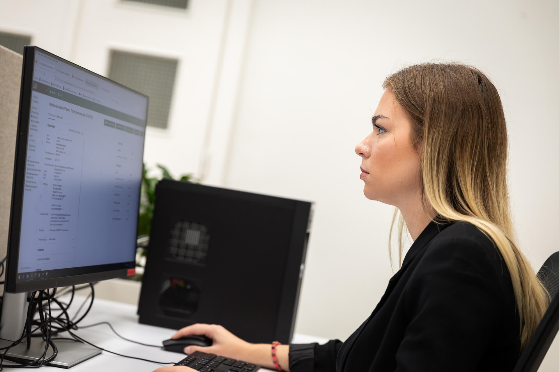 Arnold Immobilien - Arbeitssituation mit einer Mitarbeiterin vor einem Bildschirm