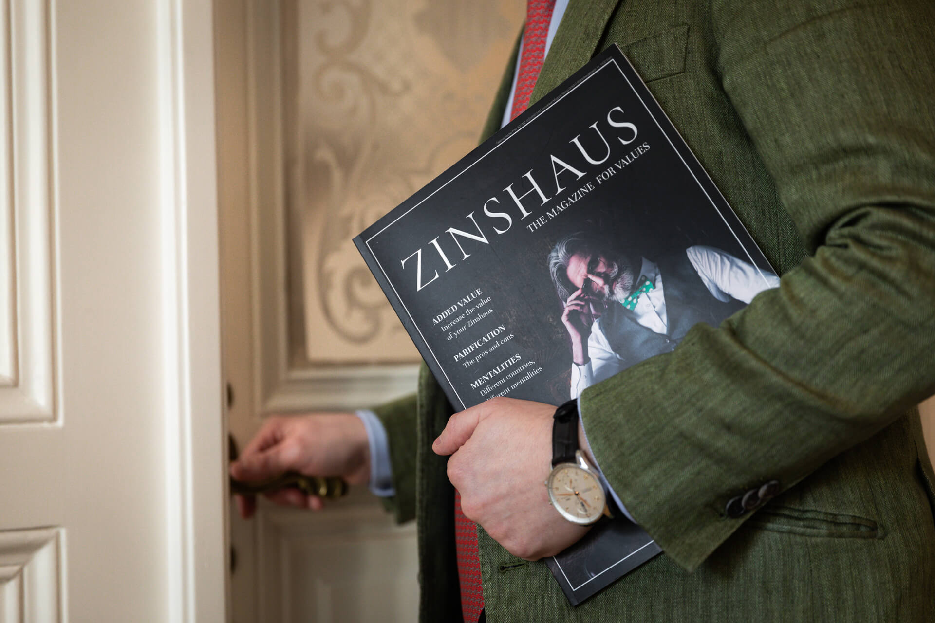 eine Hand hält das Zinshaus-Magazine von Arnold Immobilien in Händen