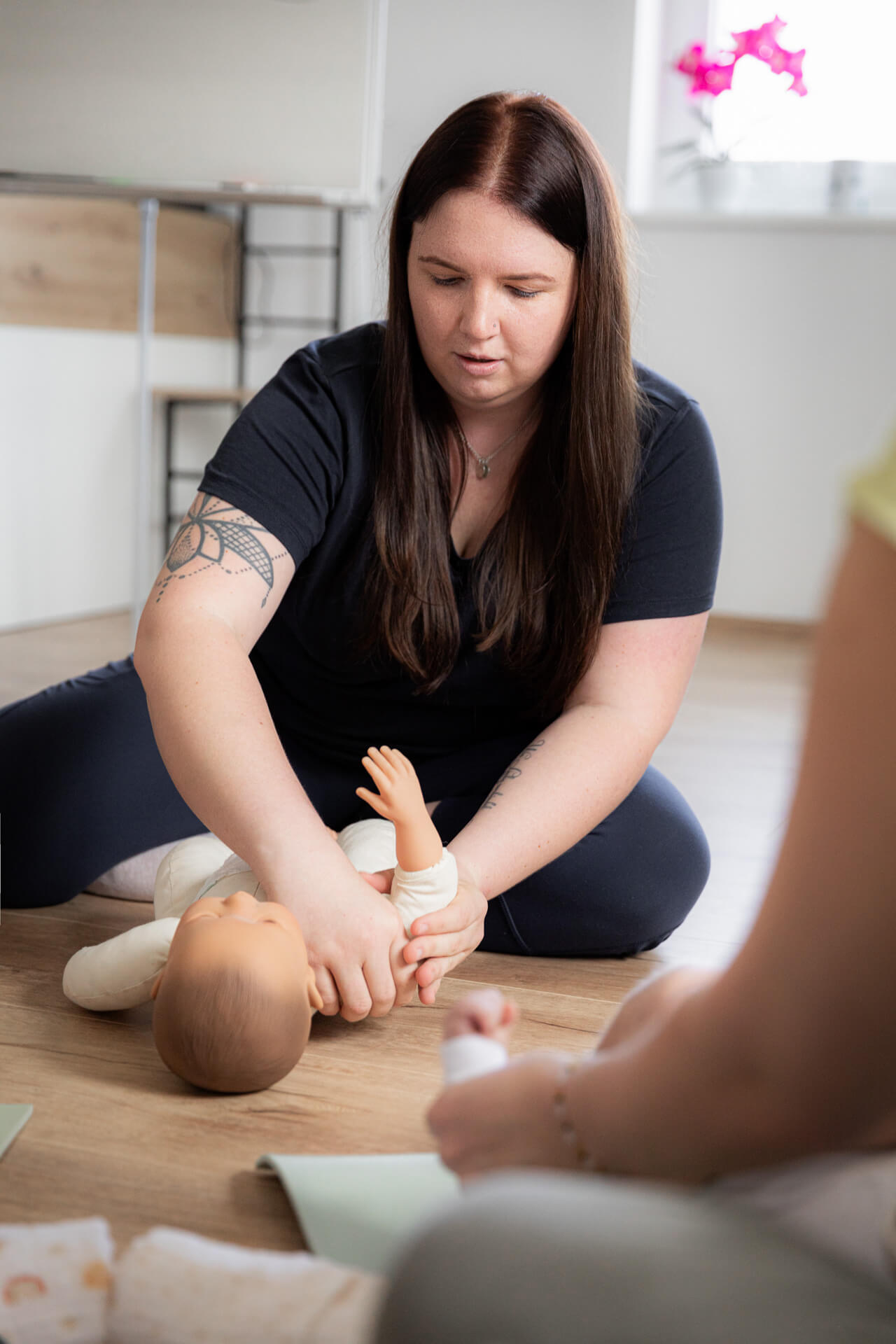An einem Baby wird eine Babymassage an der Hand vorgezeigt.