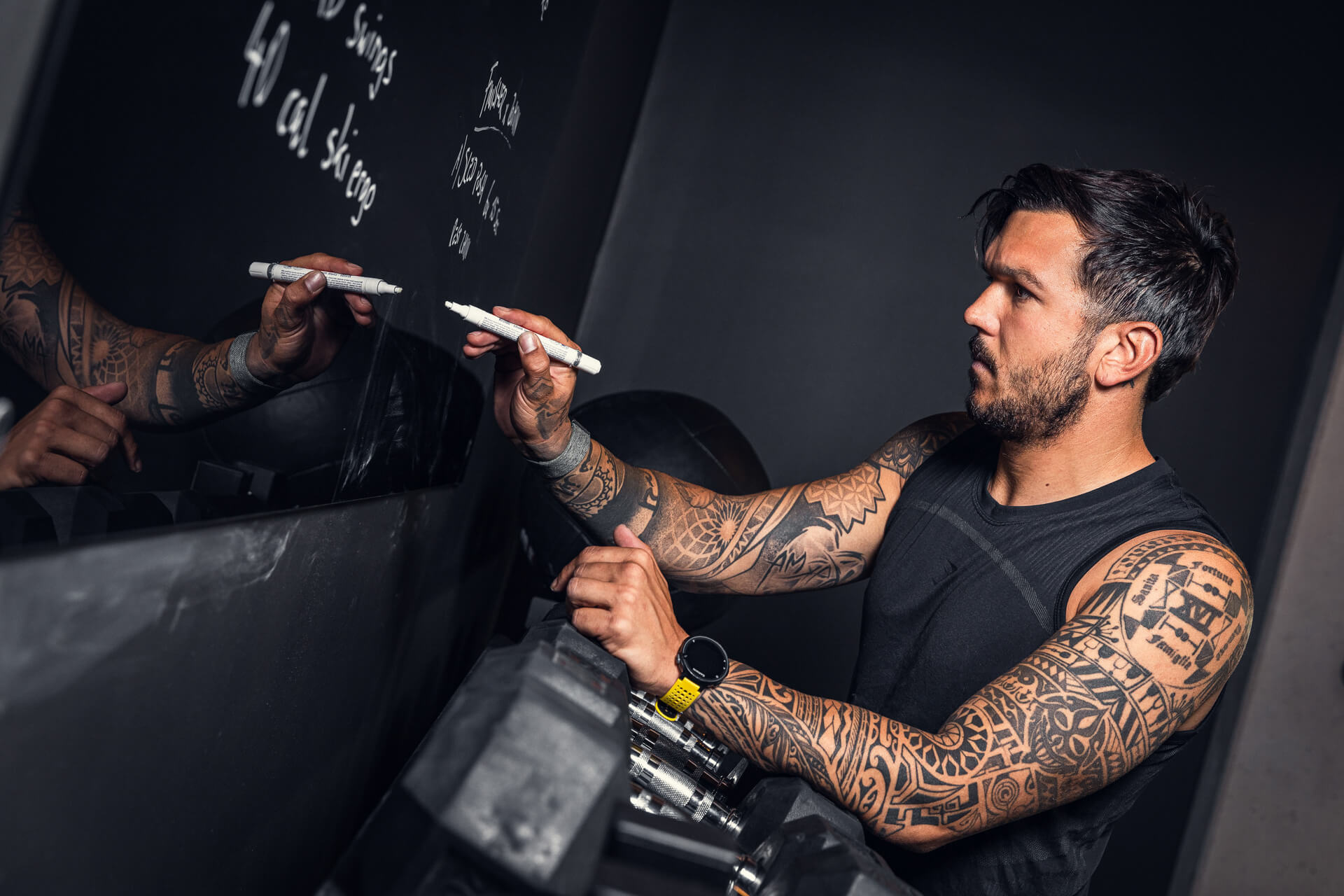 ein Fitnesstrainer schreibt gerade einen Trainingsplan an eine Wand
