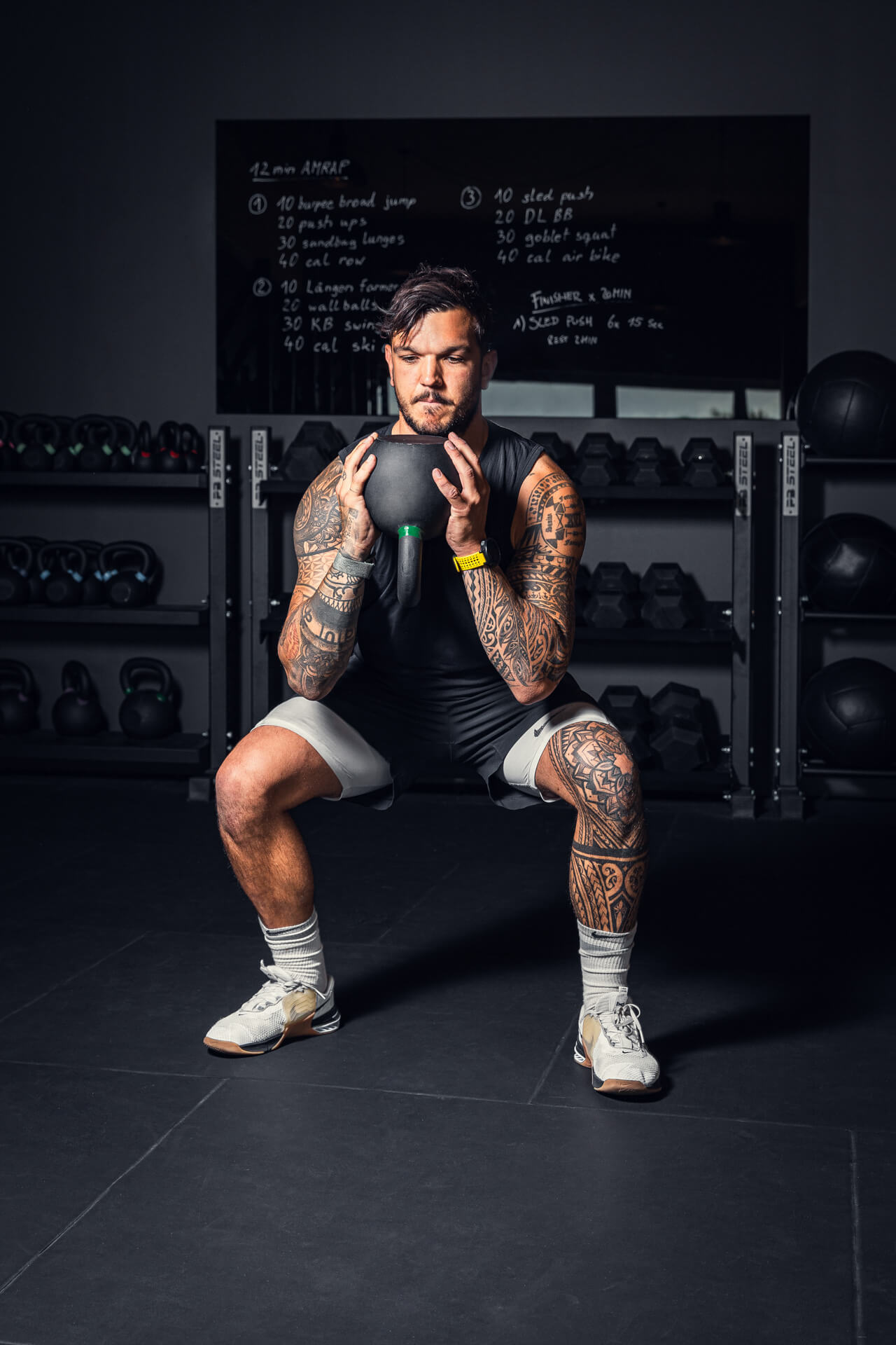 ein Fitnesstrainer hebt gerade ein Gewicht