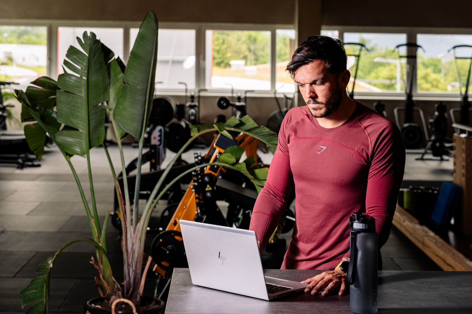 der Fitnesstrainer arbeitet an seinem Laptop